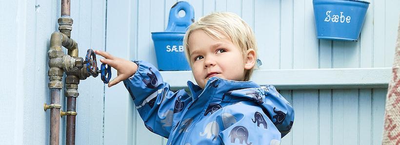 Boy in navy elephant rain set